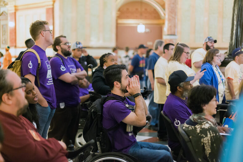 A group of community organizing group members and advocates attending a rally.