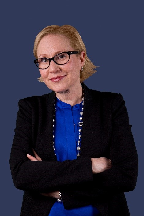 Image is of Jennifer brown, a white woman with short blonde hair and glasses. She's smiling at the camera, her arms folded across her chest.