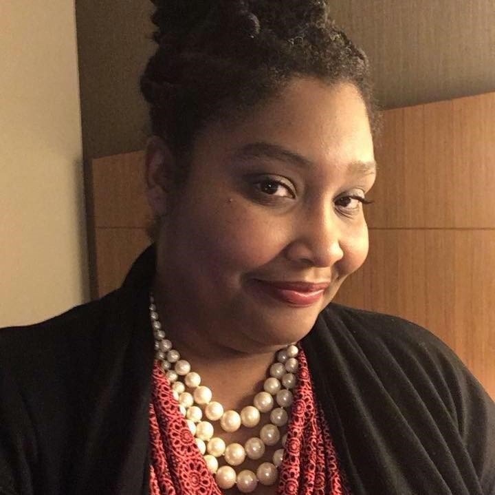 ShaRhonda Dawson, a Black woman with her hair pulled back from her face. She's wearing a pearl necklace and coral blouse.