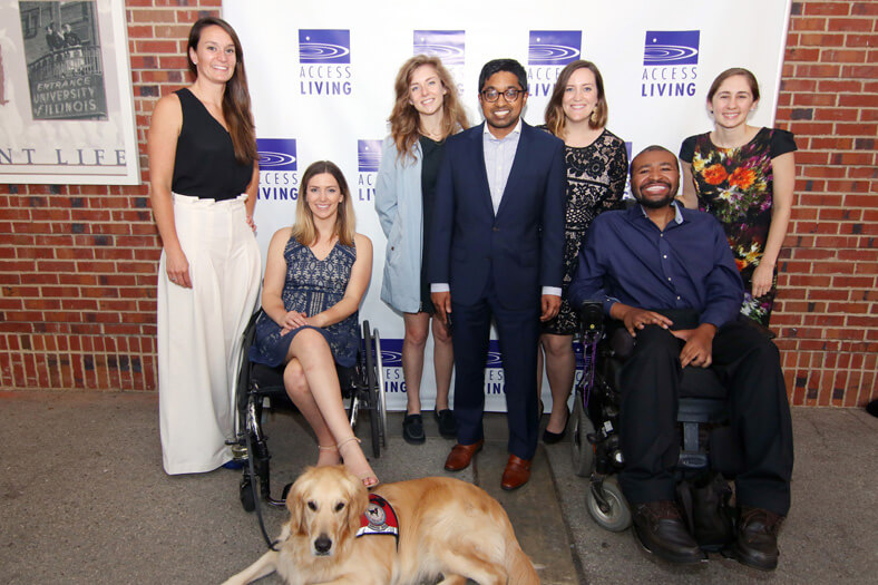 Group of young professionals poses by Access Living sign