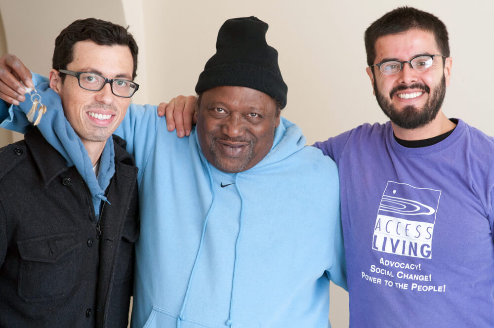 Access Living staff with a consumer who just got the keys to his home after living in a nursing home.