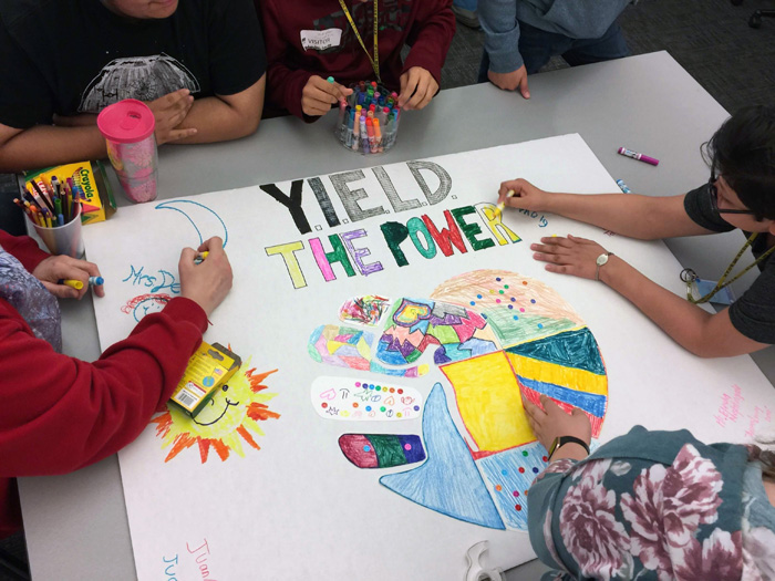 Kids working together on a poster.