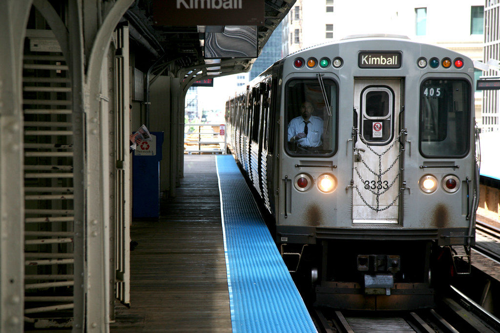 A Kimball-bound brown line train waits for passengers at an L station.