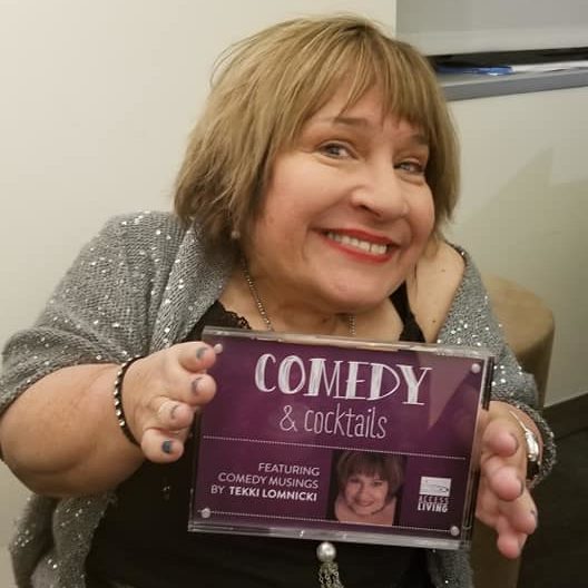 Comedian Tekki Lomnicki holding one of her comedy albums.