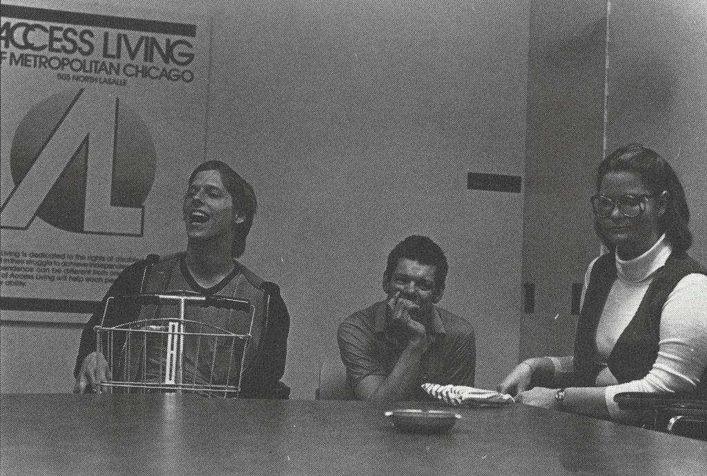 A black and white photo of Access Living consumers and staff at a workshop in 1980.