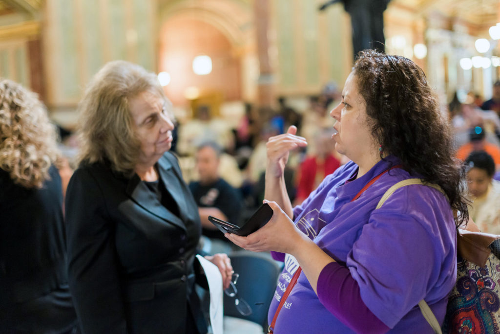 An Access Living advocate speaking with a legislator in Springfield, IL.