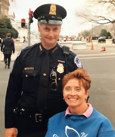 Image is of Ginger Lane, a wheelchair user, with a police officer in Washington D.C.