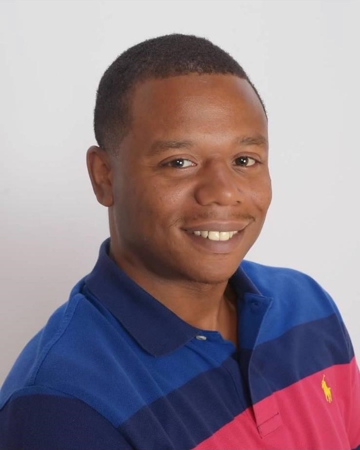 A headshot of Michael Walthall, a Black man wearing a blue and red polo shirt. He is smiling at the camera. 