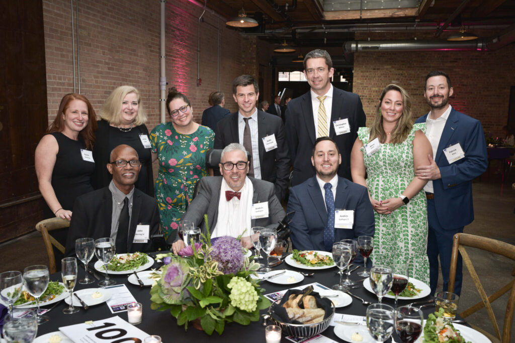 A group picture of a table of guests during dinner, including Andres Gallegos.
