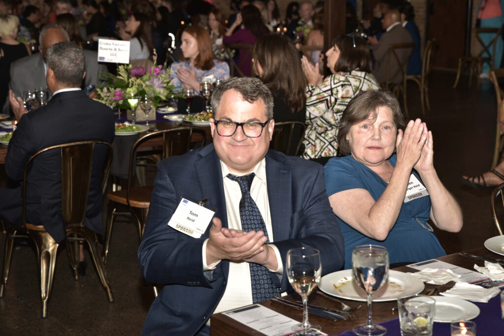 Tom Reid, a gala sponsor, and the woman seated next to him, applaud."