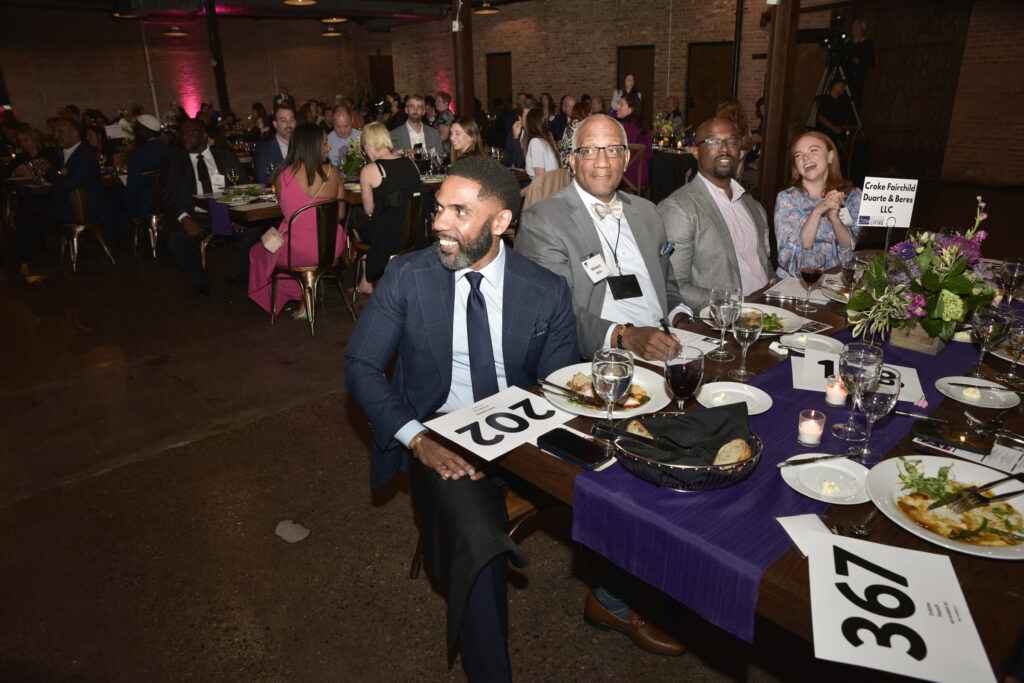 A table of guests during the paddle raise auction. They are seated at a table marked "Croke Fairchild Duarte & Beres LLC."