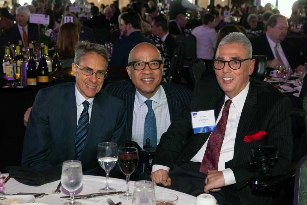 Andrés Gallegos with two other men in suits. 