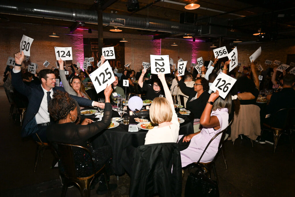 Guests raising their bid cards during the paddle raise at the 2025 Access Living Gala